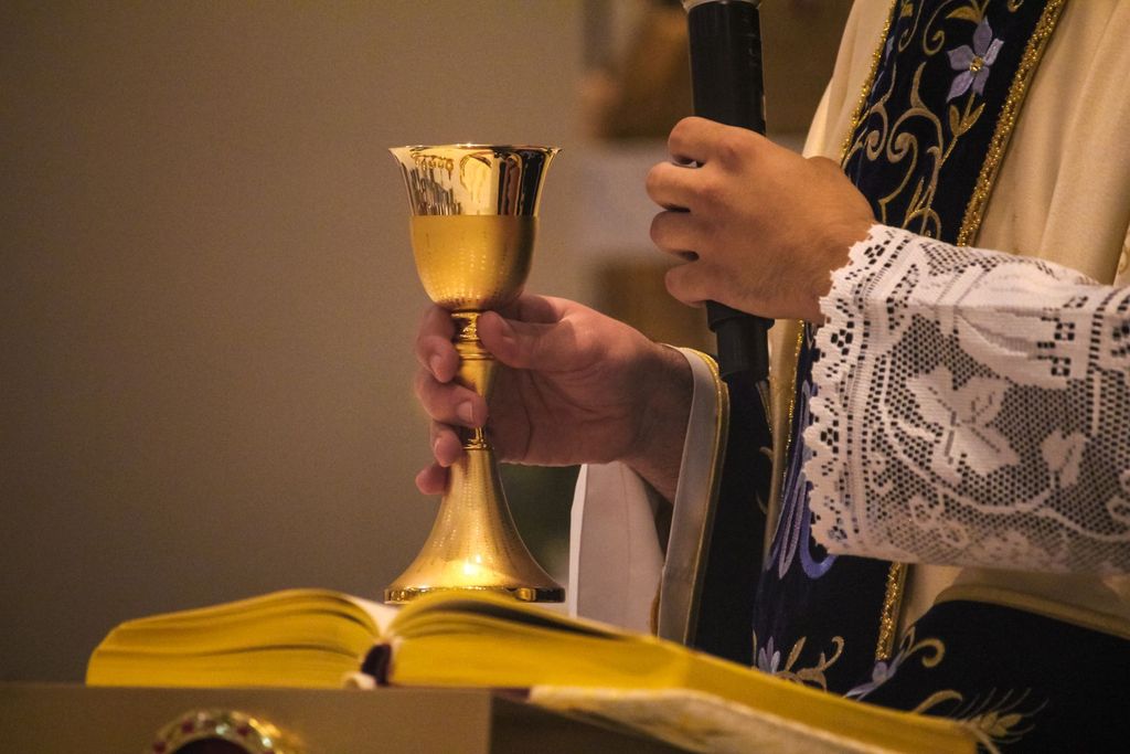A priest's hands holding the chalice at Mass