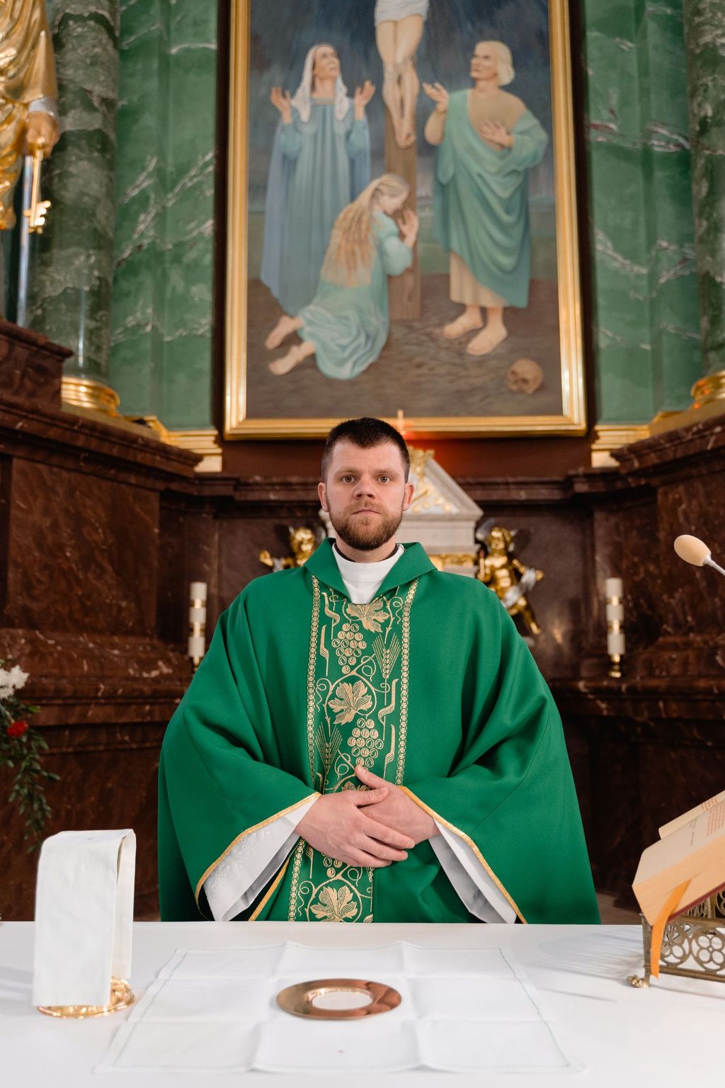 A priest in a green chasuble at the altar